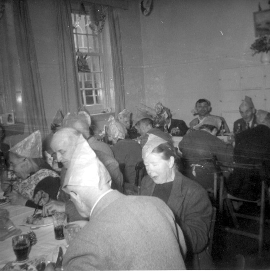 Photo:Men and women enjoy Christmas dinner in one of the House Blick day rooms, c. 1962