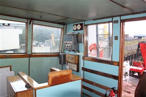 Photo:The aft starboard corner of the wheelhouse, with all the original light switches from 1960! Almost all the varnished woodwork is original, like the signal flag locker at the left of the photo.